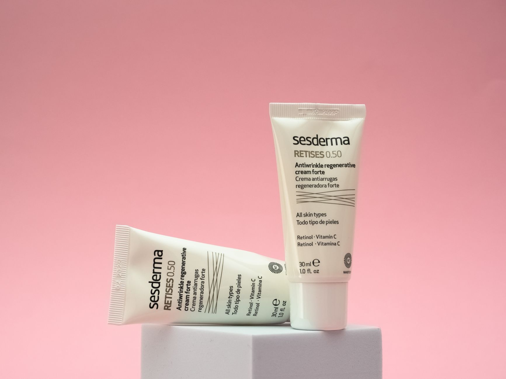 Close-up of a hand holding a dropper bottle of skincare serum with a soft focus background.