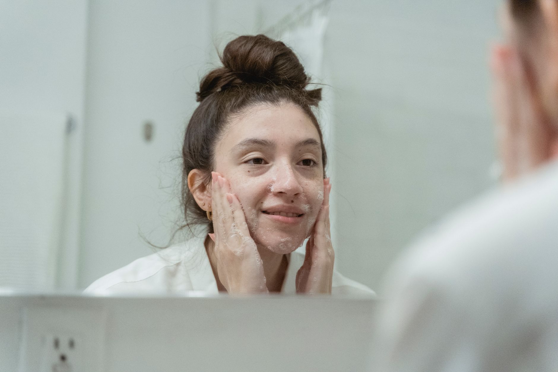 A woman with dry skin gently washing her face with a homemade cleanser.