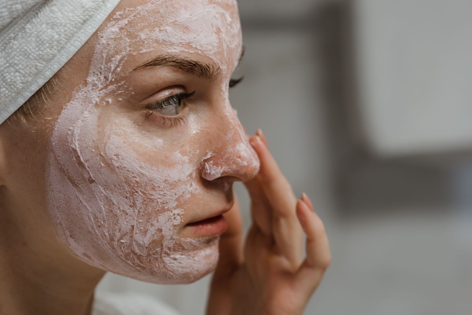 Woman applying a moisturizer to her cheek, illustrating the importance of choosing the right moisturizer ingredients that clog pores.